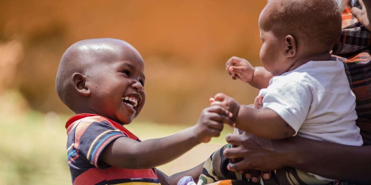 Two babies smiling and playing with each other