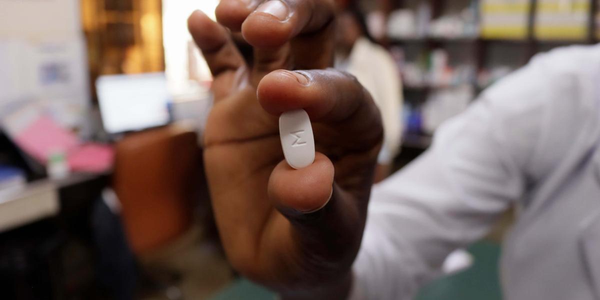 A doctor holds a tablet with a M imprint