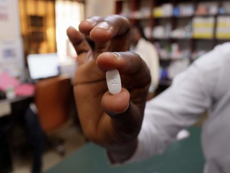 A doctor holds a tablet with a M imprint