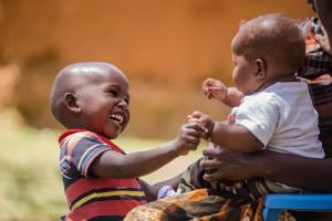 Two babies smiling and playing with each other